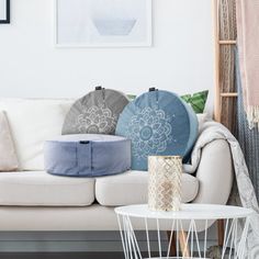 a living room filled with white furniture and lots of pillows on top of the couch