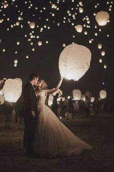 a bride and groom are holding lanterns in the air at night, with text reading sky lanterns - wedding exit chinese lanternes