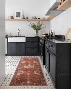 a black and white kitchen with an area rug