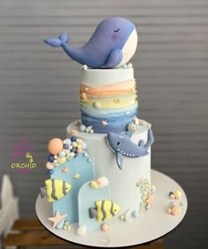 there is a cake that looks like a whale and other animals on top of it