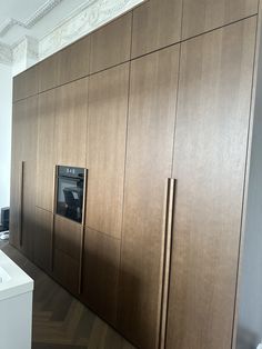 an oven built into the side of a wall in a room with wood paneling