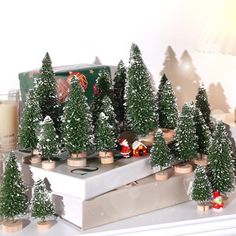 small christmas trees sitting on top of a white mantle