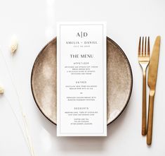 the menu card is placed on top of a plate next to gold cutlery and silverware