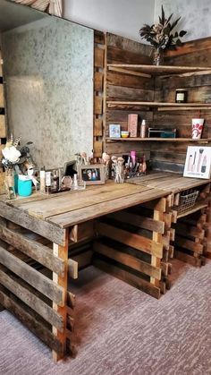 a desk made out of wooden pallets in front of a large mirror and shelves