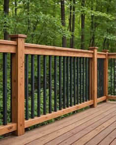 a wooden deck with black iron railings and trees in the backgroung