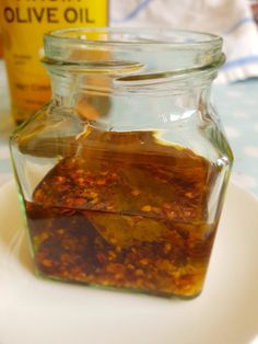 a glass jar filled with liquid sitting on top of a white plate