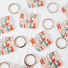 many different key chains and magnets on a white table with words that spell out the word yes