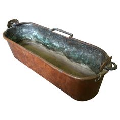 an old, rusty metal tray with handles