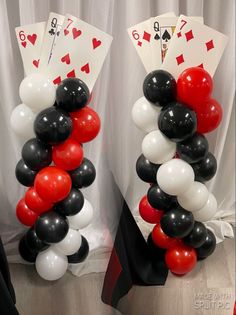 two stacks of cards and balloons in the shape of playing cards are on top of each other