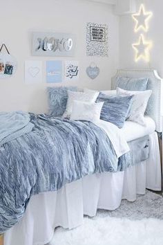 a bedroom with white and blue decor on the walls, bed linens and pillows