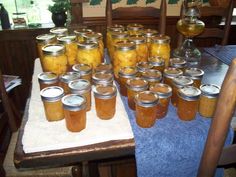 there are many jars full of pickles on the table with blue towels around them