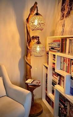 a living room filled with furniture and bookshelves next to a wall mounted lamp