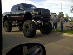 a large black truck parked on top of a parking lot