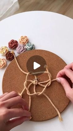 someone is making a cork board decoration with buttons