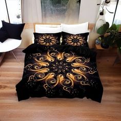 a bed covered in black and gold comforters