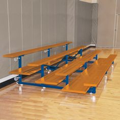 several benches are lined up in the middle of an empty gym floor with hard wood floors