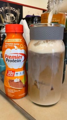 there is a jar of ice cream next to a bottle of protein drink on the counter