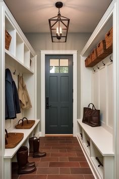 an entryway with white walls and brown tile flooring is flanked by built - in shelving