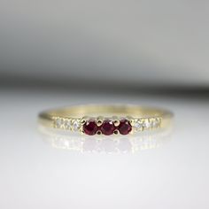 "A beautiful gemstone stacking ring, handmade in 14K Gold and set with Rubys and Diamonds. An ideal gift that is made to last a life time. Handmade by an inspired jewelry artist team with decades of experience in the craft of jewelry making. Each gemstone, each diamond is carefully picked. Using only the finest raw materials and the highest industry standard in manufacturing, design and finish. Ring Features: 3 x Natural Pink Ruby gemstones, 0.10 ct 6 x natural diamonds, 0.04 ct VS-E Ring width Ruby Stackable Round Band Promise Rings, Stackable Ruby Fine Jewelry, Stackable Ruby Jewelry In Fine Style, Adjustable Ruby Rings For Wedding, Stackable Fine Ruby Jewelry, Adjustable Ruby Wedding Ring, Elegant Stackable Ruby Birthstone Ring, Ruby Rings For Promise With Round Band, Fine Jewelry Gemstone Stackable Rings For Promise