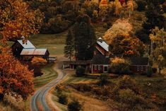 an aerial view of a country road and houses in the fall season with trees turning colors