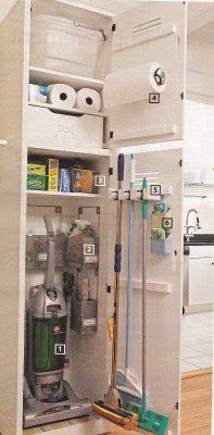 an open refrigerator in the middle of a kitchen filled with cleaning supplies and other items