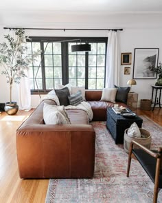 a living room filled with lots of furniture and decor on top of a wooden floor