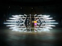 an abstract sculpture made out of lights in a dark room with no one around it