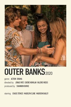 a group of people standing next to each other in front of a sign that says outer banks