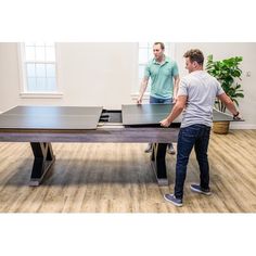 two men playing ping pong in an office