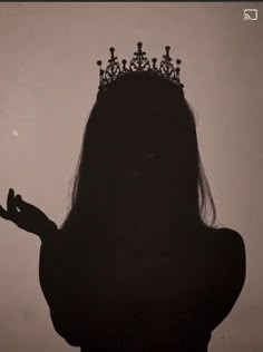 the silhouette of a woman with a crown on her head and hands in front of her face