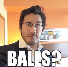 a man with glasses is looking at the camera and has words above him that say balls?