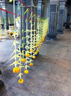 yellow flowers are tied to the side of a pillar in an ornate building with columns