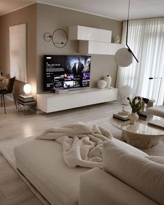 a living room filled with furniture and a flat screen tv on top of a wall