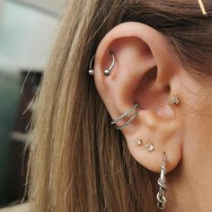 a woman wearing three different ear piercings