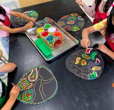 children are making crafts at a table with plates and trays on it that have been decorated