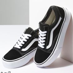 a pair of black and white vans shoes