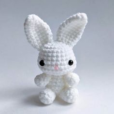 a small white crocheted bunny sitting on top of a table