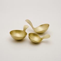 three gold spoons sitting next to each other