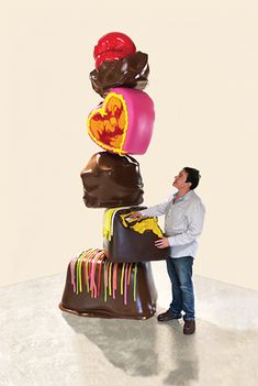 a man standing next to a giant pile of chocolates