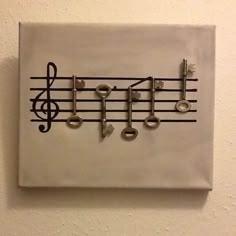 a music note made out of musical notes is mounted on a white wall with black keys