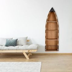 a living room with a white couch and a wooden boat shaped shelf on the wall