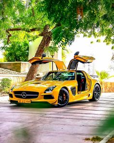 a yellow sports car parked in front of a tree