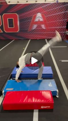 the man is practicing his acrobatic skills on the trampoline course