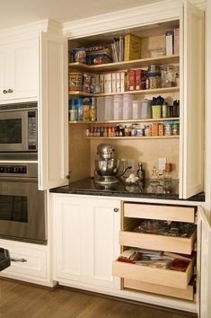 a kitchen with white cabinets and stainless steel stove top oven in the corner next to an open cabinet door