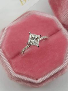 a princess cut diamond ring in a pink velvet box