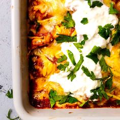 a casserole dish with chicken, cheese and parsley on top is shown