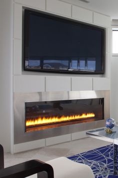 a living room with a large flat screen tv mounted above the fire place in the fireplace