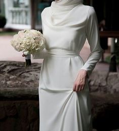 a woman in a white dress holding a bouquet