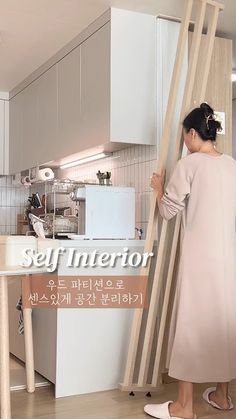 a woman standing in front of a kitchen counter with a ladder on it's side