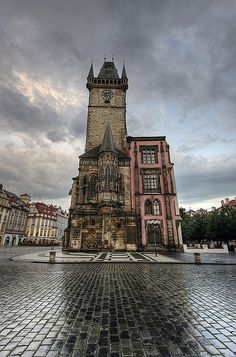 a very tall building with a clock on it's face in the middle of a city